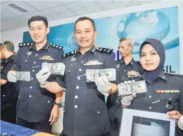  ??  ?? Mohd Sakri (second right) and his officers show the seized cash during a press conference. — Bernama photo