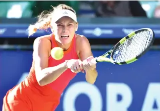  ??  ?? Caroline Wozniacki hits a return against Garbine Muguruza during their women’s singles semifinal match at the Pan Pacific Open tennis tournament in Tokyo on Saturday. (AFP)