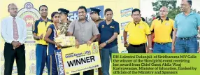  ??  ?? P.H. Lakmini Dulanjali of Siridhamma MV Galle the winner of the 5km (girls) event receiving her award from Chief Guest Akila Viraj Kariyawasa­m, Minister of Education, flanked by officials of the Ministry and Sponsors