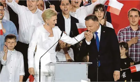  ?? FOTO REUTERS ?? Rodina je vše. Staronový polský prezident Andrzej Duda, který těsně obhájil vítězství ve volbách, líbá na znamení díků ruku své manželce Agatě.