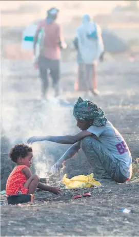  ??  ?? Flüchtling­e aus Tigray bereiten sich im Nachbarlan­d Sudan eine Mahlzeit zu.