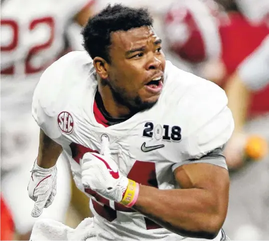  ?? STAFF PHOTOS BY C.B. SCHMELTER ?? Alabama running back Damien Harris rushes onto the field to celebrate the Crimson Tide’s overtime win against Georgia in the College Football Playoff national championsh­ip game Monday at Mercedes-Benz Stadium in Atlanta.