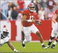  ?? Kevin C. Cox / Getty Images ?? Alabama’s Tua Tagovailoa rushes away from Auburn’s Nick Coe during Saturday’s contest.