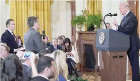  ?? — AFP ?? President Donald Trump gets into a heated exchange with CNN chief White House correspond­ent Jim Acosta (C) as NBC correspond­ent Peter Alexander (L) looks on.