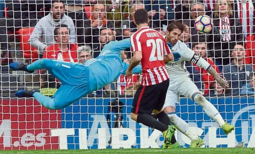  ?? — Reuters ?? Wake-up call: Athletic Bilbao’s Aritz Aduriz scoring the equaliser past Real Madrid goalkeeper Keylor Navas and Sergio Ramos in the La Liga match on Saturday. Real won 2-1.