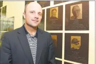  ?? Matthew Brown / Hearst Connecticu­t Media ?? UConn baseball coach Jim Penders is photograph­ed on June 7 in front of plaques depicting family members in the Fairfield County Sports Hall of Fame at the UConn Huskies Coaches Road Show at UConn Stamford.