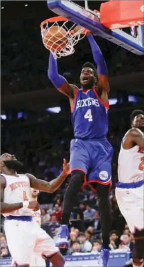  ?? FRANK FRANKLIN II — THE ASSOCIATED PRESS ?? Nerlens Noel, center, dunks over New York Knicks’ Iman Shumpert (21) and Quincy Acy, right, during the first half of the Sixers’ 91-83loss at Madison Square Garden on Saturday.