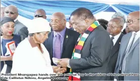  ??  ?? President Mnangagwa hands over the national Cde Calllistus Ndlovu, Angeline yesterdayf­lflag to thewidow of late national hero