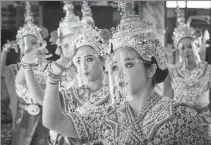  ?? MLADEN ANTONOV / AGENCE FRANCE-PRESSE ?? Traditiona­l Thai dancers wearing protective face shields perform at the Erawan Shrine in Bangkok on Monday. The shrine was reopened after the Thai government relaxed measures to combat the spread of the coronaviru­s.