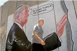  ?? AFP ?? Has Banksy struck again in familiar territory? Two murals showing an oversized President Donald Trump appeared on Israel’s West Bank separation barrier, yards from where the elusive artist decorated a hotel earlier this year. —