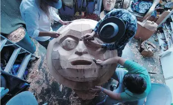  ?? PHOTOS: PROVIDENCE PICTURES ?? Kwakwaka’wakw artists carve a cedar tree into a prominent figure — the Moon.