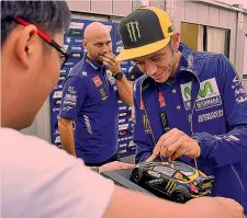  ?? AFP ?? Valentino Rossi, 38 anni, firma un modellino della Fiesta da rally