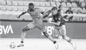  ?? Karen Warren / Staff photograph­er ?? Dynamo midfielder Derrick Jones, left, fights for the ball against Diego Rubio in the first half. After tying the game, the Dynamo conceded two second-half goals.