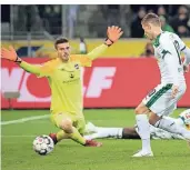  ?? DPA ?? Gladbachs Thorgan Hazard schiebt zum 1:0 an Nürnbergs Torwart Fabian Bredlow vorbei. Denis Zakaraia schaut zu.FOTO: