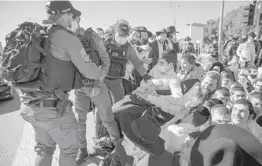  ?? ODED BALILTY/AP ?? Israeli police officers and ultra-Orthodox Jews clash Sunday in the port city of Ashdod. Police were sent to close schools that violated coronaviru­s lockdown rules.