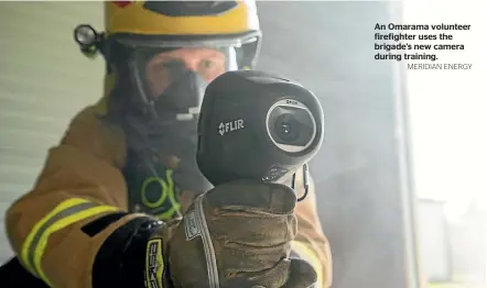  ?? MERIDIAN ENERGY ?? An Omarama volunteer firefighte­r uses the brigade’s new camera during training.