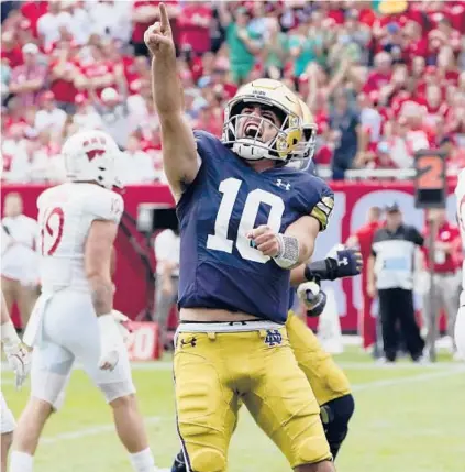  ?? CHARLES REX ARBOGAST/AP ?? Notre Dame quarterbac­k Drew Pyne celebrates his touchdown pass against Wisconsin on Saturday in Chicago.