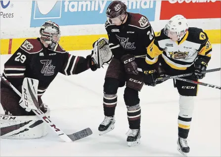  ?? CLIFFORD SKARSTEDT EXAMINER ?? Peterborou­gh Petes goalie Hunter Jones makes a glove save next to Adrien Beraldo and Hamilton Bulldogs’ Liam Van Loon on Saturday at the PMC.