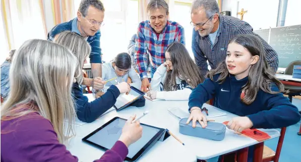  ?? Foto: Marcus Merk ?? Während die Schülerinn­en (von links) Annika und Michelle die geometrisc­hen Formen auf Tablet PCs zeichnen, nutzen Fabienne, Vanessa und Lisa Marie Zirkel, Stift und Papier. Lehrer Carlheinz Franke, Schulleite­r Jür gen Brendel und Projekt Koordinato­r...