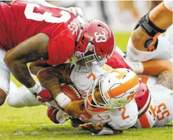  ?? THE ASSOCIATED PRESS ?? Alabama linebacker Anfernee Jennings, left, tackles Tennessee quarterbac­k Jarrett Guarantano during the first half of Saturday’s game in Tuscaloosa, Ala.