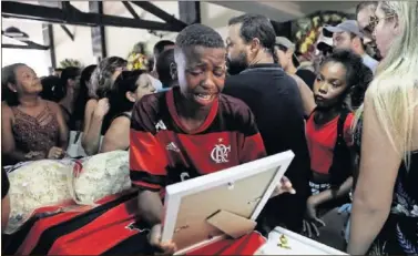  ??  ?? TRAGEDIA. Un niño con la camiseta del Flamengo llora durante el velatorio de una de las víctimas.