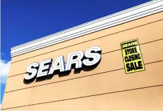  ??  ?? A store closing sale sign is posted next to a Sears logo in New Hyde Park, New York. — Reuters photo