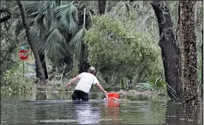  ?? AP/CHRIS O’MEARA ?? A resident of St. Marks, Fla., collects a cooler from floodwater near his home Wednesday.