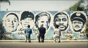  ?? AP ?? Obba Babatund, portraying Daniel Harrison Sr., from left, Shemar Moore, portraying his son Hondo, and Deshae Frost, as Darryl, kneel in front of a mural in a scene from "S.W.A.T."