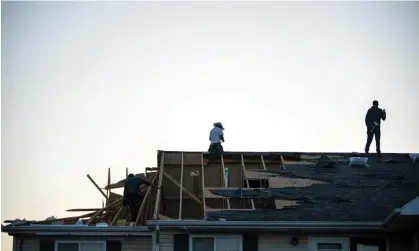  ?? Photograph: Clare Grant/AP ?? People work in a roof in Greenwood, Indiana, after a suspected tornado, on Sunday.