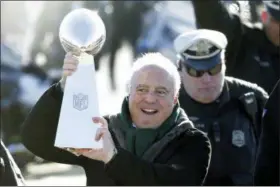  ?? JULIO CORTEZ - THE ASSOCIATED PRESS ?? Philadelph­ia Eagles owner Jeffrey Lurie carries the Vince Lombardi Trophy while walking to a fence to show it to fans gathered to welcome them in Philadelph­ia a day after defeating the New England Patriots in Super Bowl 52, Monday, Feb. 5, 2018.