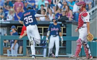  ?? AP PHOTO/JOHN PETERSON ?? Kevin Graham scores for Ole Miss during the first inning of Game 1 of the College World Series finals against Oklahoma on Saturday night in Omaha, Neb. Ole Miss won 10-3 to open the best-of-three series.