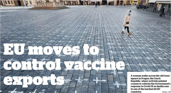  ?? Photo / AP ?? A woman walks across the old town square in Prague, the Czech Republic, where activists painted crosses to criticise the Government’s response to Covid-19 as deaths soar in one of the hardest-hit EU countries.