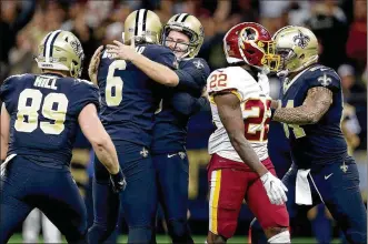  ?? SEAN GARDNER / GETTY IMAGES ?? Saints kicker Will Lutz (center) celebrates with his teammates after his 28-yard field goal in overtime lifted the team to its eight straight win. The Saints defeated the Redskins 34-31.