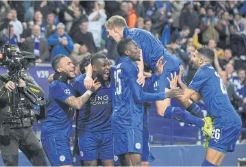  ?? AP ?? Leicester’s Wes Morgan, second left, celebrates with teammates after scoring against Sevilla at the King Power Stadium.