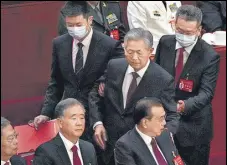  ?? AP ?? Ex-Chinese president Hu Jintao (centre) touches the shoulder of Premier Li Keqiang as he is assisted to leave the hall during the closing ceremony in Beijing on Saturday.