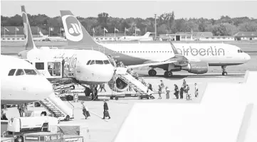  ?? — Reuters photo ?? Passengers board an Air Berlin aircraft at Tegel airport in Berlin, Germany. A first round of formal talks for the sale of insolvent German airline Air Berlin’s assets will be held with its bigger local rival Lufthansa yesterday, ahead of other...