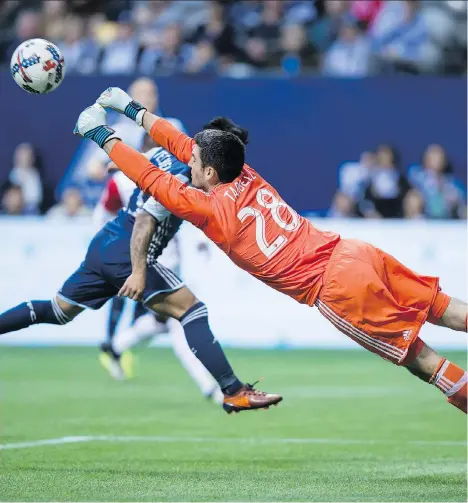  ?? THE CANADIAN PRESS ?? San Jose Earthquake­s’ keeper Andrew Tarbell dives to punch the ball away from the Whitecaps’ Cristian Techera, in background, during the second half of their MLS game in Vancouver on Sunday. The Caps must now defeat Portland to nail down first in the...