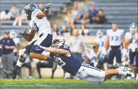  ?? Catherine Avalone / Hearst Connecticu­t Media ?? Yale’s Daniel Debner trips up Maine’s Micah Wright Saturday at the Yale Bowl in New Haven.