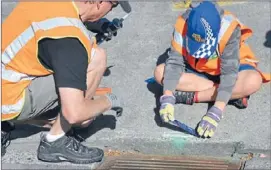  ?? Photo: SUPPLIED ?? Glue a clue: A student from Tawa School glues one of the distinctiv­e signs in place.