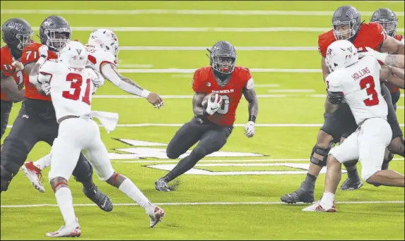  ?? Erik Verduzco Las Vegas Review-Journal @Erik_Verduzco ?? UNLV running back Charles Williams runs through a nice hole against Fresno State in a game the Rebels had a season-high in rushing yards.