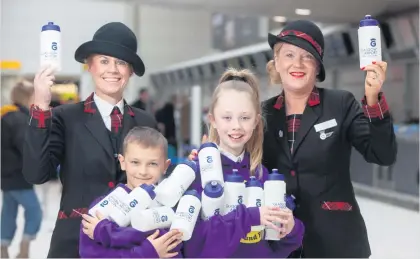  ??  ?? Bottling itLoganair cabin crew Jaymie Elliot and Linda McClean with school children Artur Wrobel and Kennedy Brown