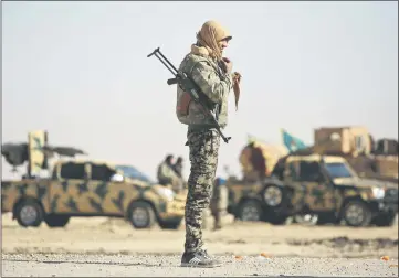  ??  ?? A fighter from the Syrian Democratic Forces gathers near a village north-east of Raqa. — AFP photo