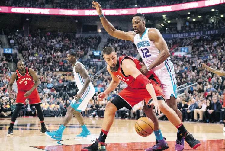  ?? FRANK GUNN / THE CANADIAN PRESS FILES ?? It will be a lighter Dwight Howard — seen here playing against the Raptors’ Jonas Valanciuna­s — on the court this year compared to last season when he was with the Hornets.