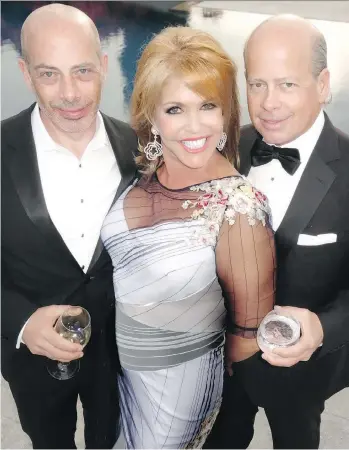  ?? PHOTOS: MALCOLM PARRY ?? Face The World charity founder Jacqui Cohen, centre, is flanked by supporters Neil and David Aisenstat, who catered her recent at-home gala with dishes from their restaurant­s.