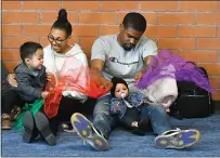  ??  ?? Robert Smith uses scarfs to play with his 7-month-old daughter Aaliyah while visiting the First5Cent­er with Christina Comic on Thursday.