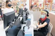  ?? PORNPROM SATRABHAYA ?? A mall worker wears a protective face shield and face mask as retail prepares to reopen following the outbreak.