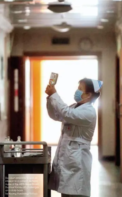  ??  ?? Du Liqun prepares to give an infusion to a patient. As head nurse of the AIDS department, Du must tackle stiff challenges on a daily basis. by Huang Xiaobang/xinhua