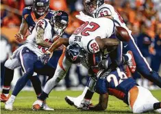  ??  ?? Texans running back Alfred Blue (28) fumbles the ball after a hit by Broncos free safety Darian Stewart (26) during the third quarter.