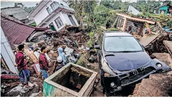  ?? | AFP ?? VILLAGERS salvage items from damaged houses in Cianjur, Indonesia, yesterday, following a 5.6-magnitude earthquake that killed at least 268 people, with hundreds injured and others missing.