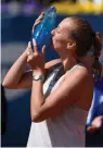  ?? — AFP ?? Petra Kvitova of the Czech Republic kisses the trophy after defeating Romania’s Mihaela Buzarnescu in their final tennis match at the WTA Prague Open on Saturday.